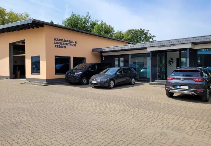 Gebäude des Karosserie- & Lackzentrums Zeesen mit Autos davor.